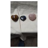 Three polished heart stones. Rose quartz, tigers