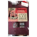 Box of cookie cutters and 2 small tape measurers