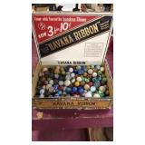 Cigar box full of assorted marbles, some rock