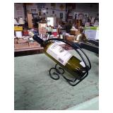 Wine bottle display/holder. Adorned with an empty
