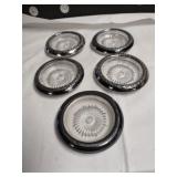 Group of five silver-plated glass drink coasters.