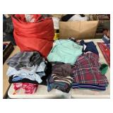 Sleeping bag and mixed size clothing, some with