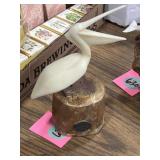 John Perry pelican sculpture on a natural wood