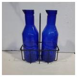 Blue glass milk bottles and wire carrier
