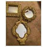 Three decorative gold colored wall mirrors