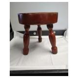 Vintage small red three-legged footstool.