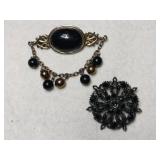 Two dark stone brooches