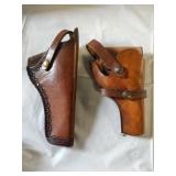 Pair of leather pistol holsters. One marked for