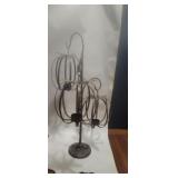 This wrought iron candle holder features a