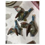 Plaster hanging ducks, one has damage on wings