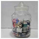 Glass jar with thread and buttons
