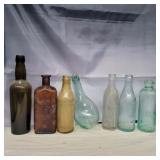 7 glass bottles various sizes and colors