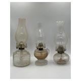 3 clear glass oil lamps, left is Lamplight Farms