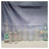 7 glass pop bottles and 2 glass salt and peppers