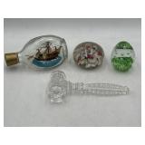 Glass paper weights, gavel, and ship in a bottle