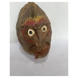 Coconut with carved face in it