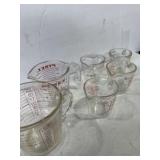 Five glass Pyrex measuring cups and one glass