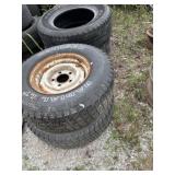 Four large truck tires, two with rims