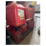 Five gas cans of various sizes and a metal crate