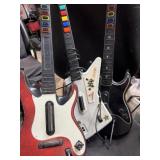 Three guitar hero guitars