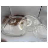 Four Pyrex glass lids, and one oval amber glass