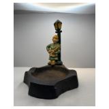 A baker leaning on a light pole. Cast iron.