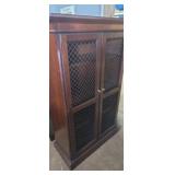 Wooden bookcase featuring wire mesh doors and a