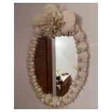 oval wall mirror framed with layered natural