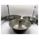 Three metal angel food or Bundt cake pans.