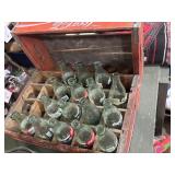 Collectible Coca-Cola bottles in wooden Coke