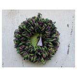 A lighted up and scary witch Halloween wreath.
