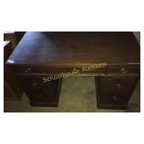 Dark wood desk. 
Features 7 drawers in total. 4