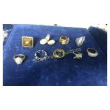 9 assorted rings. Tiger eye marked NR, rest