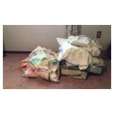 Pile of blankets, sheets, pillows and cases. A