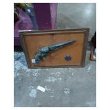 Group of wall art.   A framed pistol with star