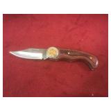 Pocket knife w/ 1961 penny on wood