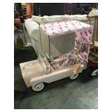 Pink pressed steel pedal car with a doll driver