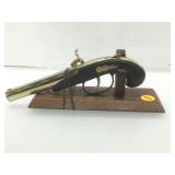 Replica pistol lighter on display stand.