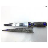 Decorated knife in matching ornate metal sheath.