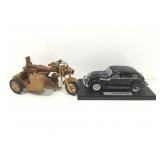 Model car on display stand and wooden motorcycle.