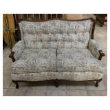 Vintage wood frame loveseat w/floral print.
