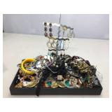 Earrings on stand and lot of assorted jewelry.