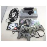 Playstation with controllers and assorted games.