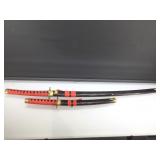 Pair of decorative swords in black sheath.