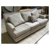 Cream couch w/studded accents, approx 7 ft long