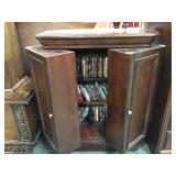 Wooden DVD storage cabinet filled with dvds