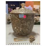 Metal canister with tongs.