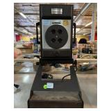 Polaroid camera on laminex stand.