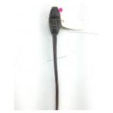 A carved wooden staff with stylized human face at