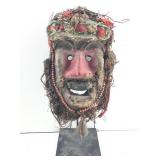A hand carved African tribal mask featuring mixed
